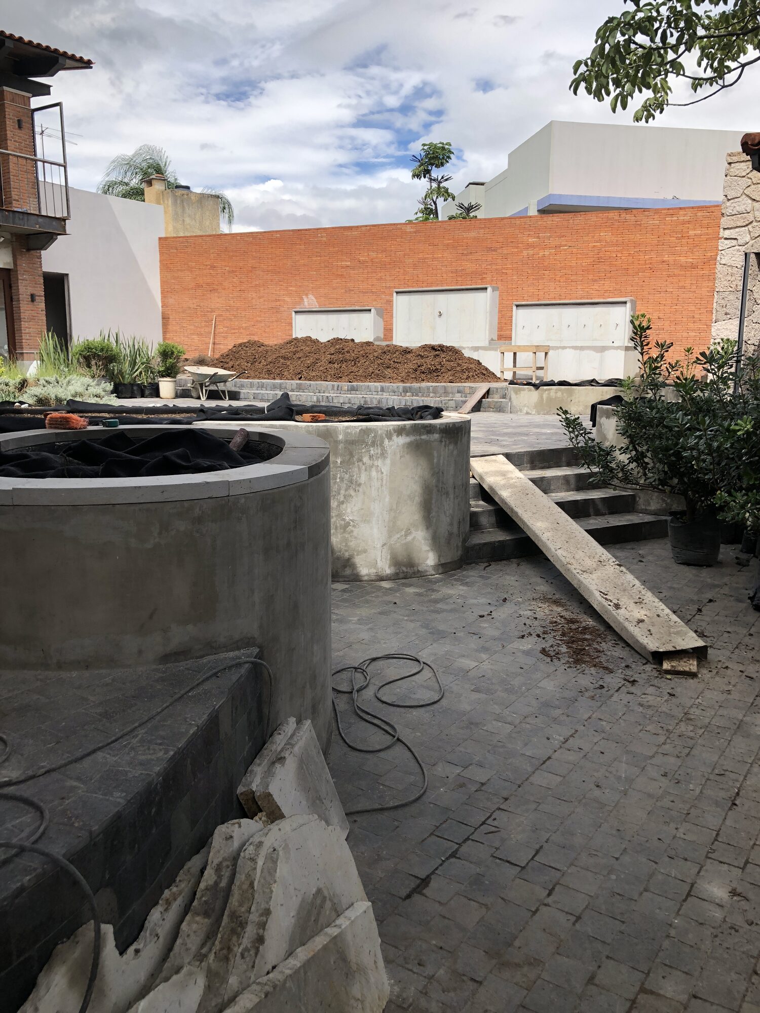 A planted courtyard beside a textured wall.