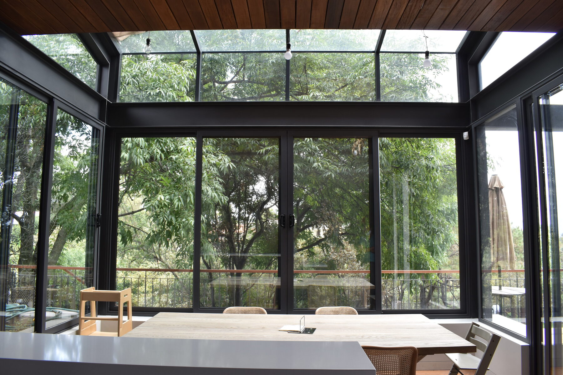 The pavilion from another angle, black frames against the greenery.