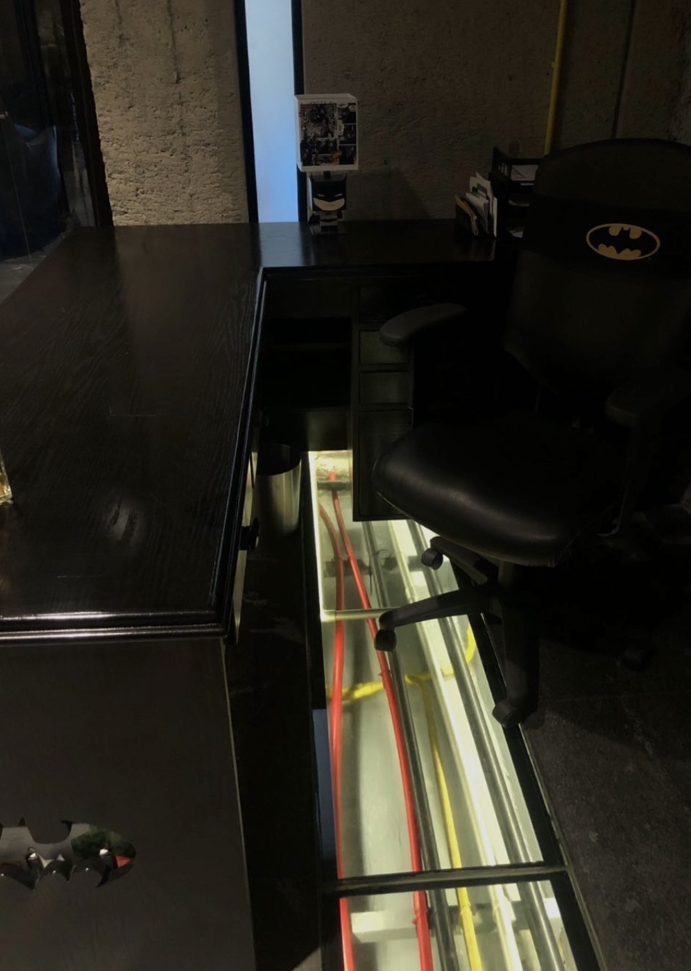 A glass display case against black surfaces in a dim room.